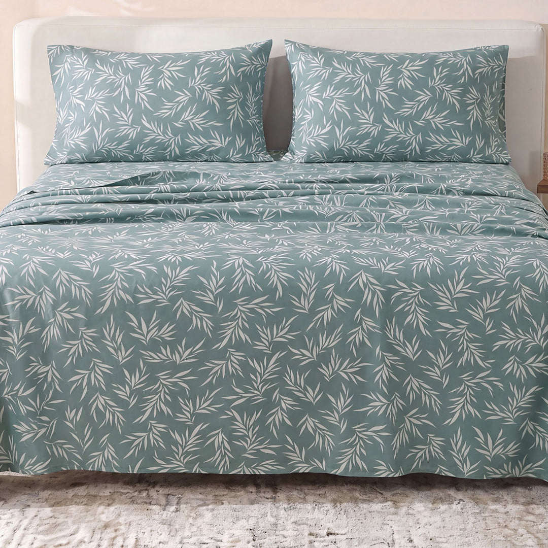 Sofia Home Textiles Printed Bedsheets - Sofia Leaves Printed Double Flat Bedsheet Set 4 Pcs (240 × 260 cm) in Teal spread on a double bed - مفروشات صوفيا - ملايات مطبوعة - طقم ملاية صوفيا ورق شجر دبل مسطحة 4 قطع (240 × 260 سم) باللون جنزاري مفروش على سرير دبل