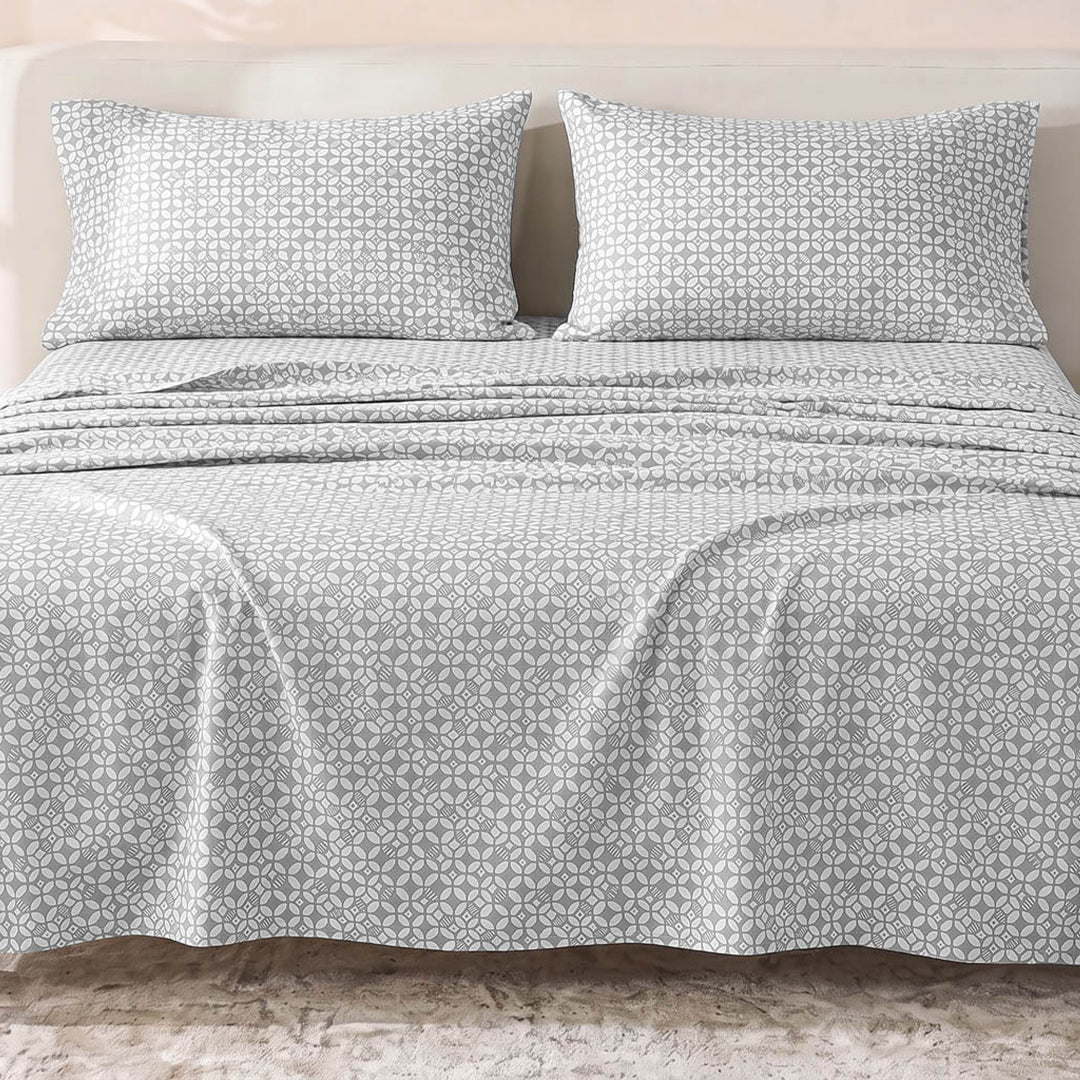 Sofia Home Textiles Printed Bedsheets - Sofia Geometric Flowers Printed Double Flat Bedsheet Set 4 Pcs (240 × 260 cm) in Dark Grey spread on a double bed - مفروشات صوفيا - ملايات مطبوعة - طقم ملاية صوفيا ورد هندسي دبل مسطحة 4 قطع (240 × 260 سم) باللون رمادي غامق مفروش على سرير دبل