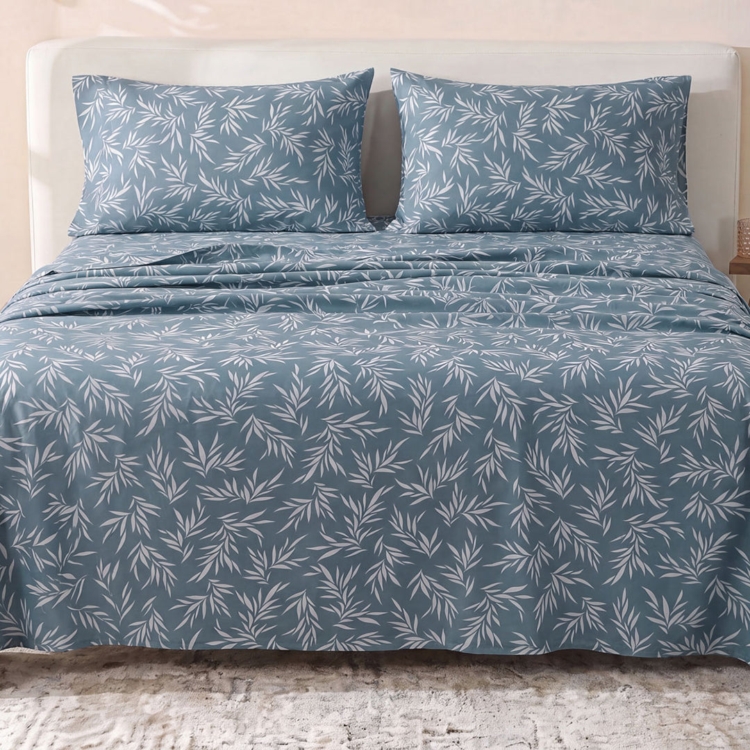 Sofia Home Textiles Printed Bedsheets - Sofia Leaves Printed Double Flat Bedsheet Set 4 Pcs (240 × 260 cm) in Petroleum spread on a double bed - مفروشات صوفيا - ملايات مطبوعة - طقم ملاية صوفيا ورق شجر دبل مسطحة 4 قطع (240 × 260 سم) باللون بترولي مفروش على سرير دبل